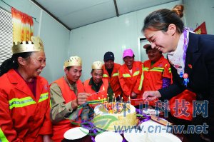 社區(qū)工作人員為集體過生日的三名環(huán)衛(wèi)工人點上生日蠟燭。 本報通訊員 趙松 攝