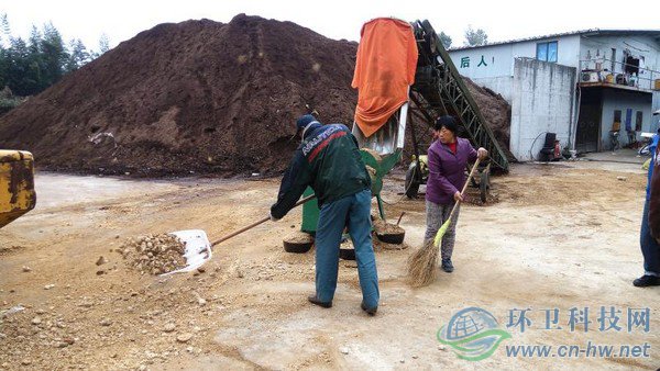 工人將機器碾碎的園林廢棄物鏟入發(fā)酵堆，噴灑生物菌劑攪拌后，自然發(fā)酵兩到四個月，就能成為有機介質(zhì)，用來改良土壤